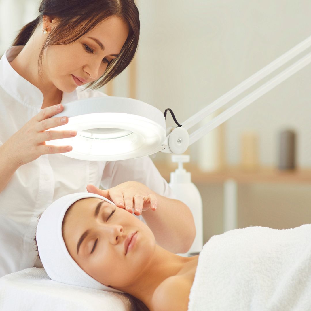 Licensed esthetician performing professional facial treatment at spa